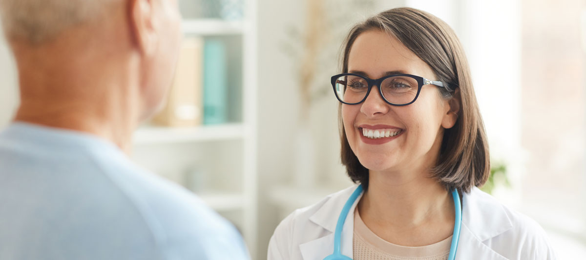 Smiling Female Doctor Looking At Senior Patient