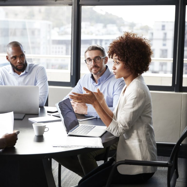 Millennial black businesswoman addressing colleagues at a corporate business meeting, close up
